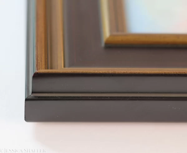 Corner view of black frame with gold bevel