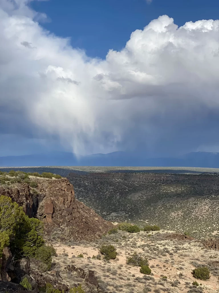 Rain clouds over the plains from the Blue Dot trail in Los Alamos, New Mexico